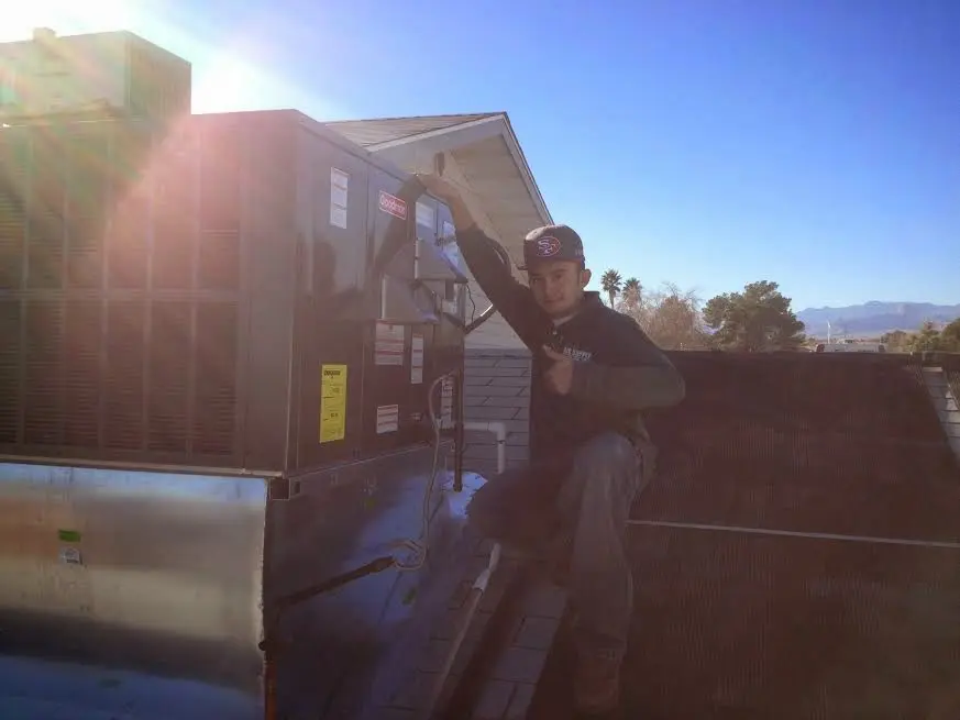 HVAC technician performing AC Tune-Up on a rooftop unit in Aurora